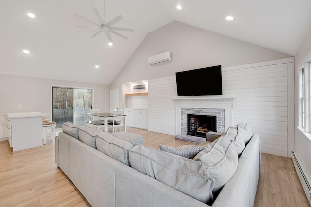 living area with an AC wall unit, a brick fireplace, light wood-type flooring, and baseboard heating