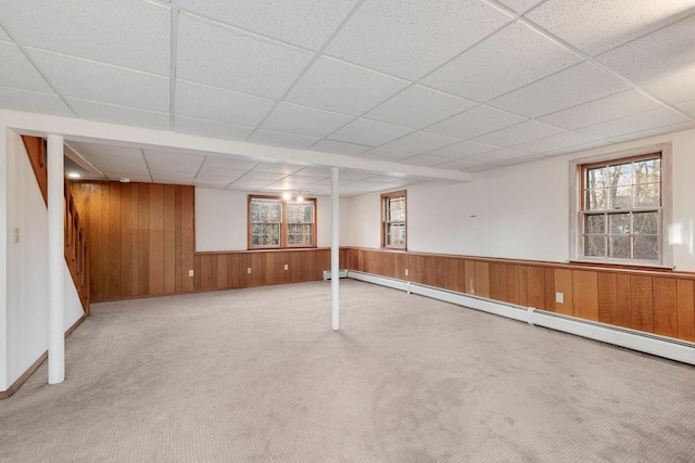 basement with wooden walls, plenty of natural light, carpet floors, and wainscoting