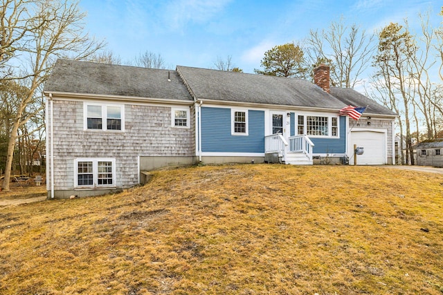 view of front of home featuring a front lawn, an attached garage, roof with shingles, and a chimney