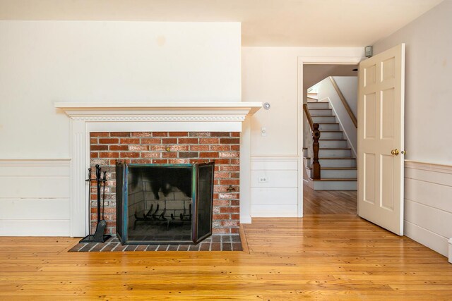 40 Thacher Shore Rd, Yarmouth Port, MA 02675 - detailed view of a fireplace with flush hearth, wood finished floors, and wainscoting