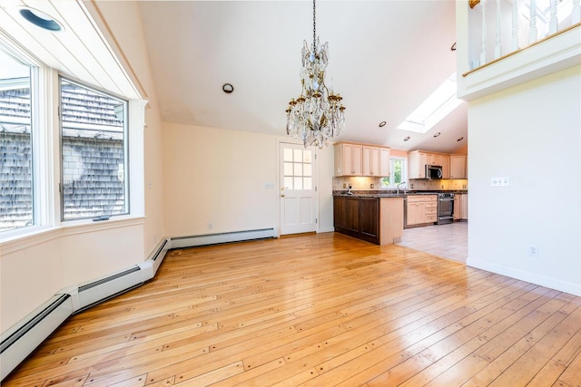 40 Thacher Shore Rd, Yarmouth Port, MA 02675 - unfurnished living room featuring a chandelier, light wood finished floors, vaulted ceiling, a sink, and a skylight