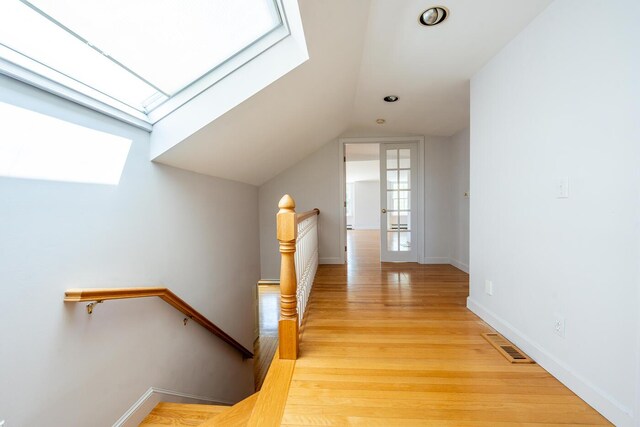 40 Thacher Shore Rd, Yarmouth Port, MA 02675 - hall featuring an upstairs landing, a skylight, wood finished floors, vaulted ceiling, and baseboards