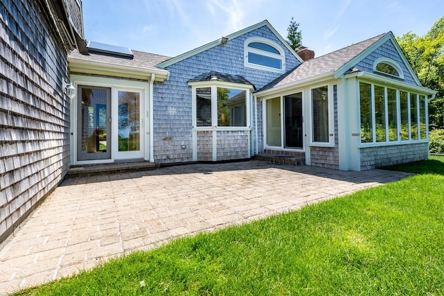 40 Thacher Shore Rd, Yarmouth Port, MA 02675 - rear view of property featuring a chimney, a sunroom, a patio area, and roof with shingles