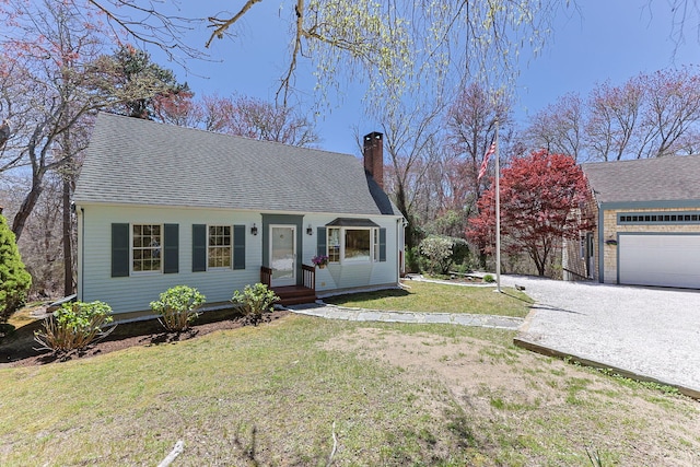 view of front of home with a shingled roof, a front yard, and a chimney
