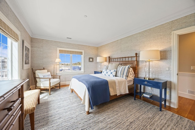 bedroom with wood finished floors, ornamental molding, wallpapered walls, and baseboards
