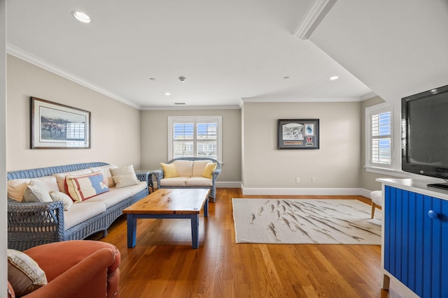 living room featuring healthy amount of natural light, light wood finished floors, baseboards, ornamental molding, and recessed lighting