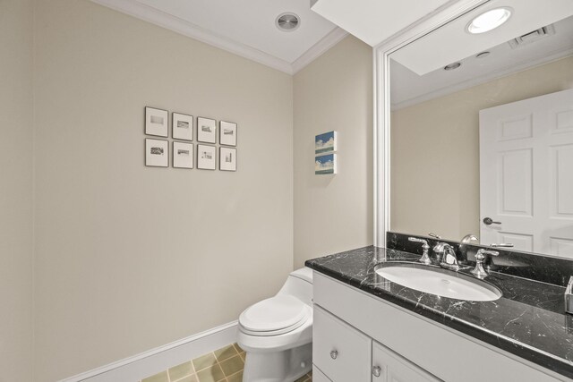 half bathroom with baseboards, ornamental molding, vanity, and toilet