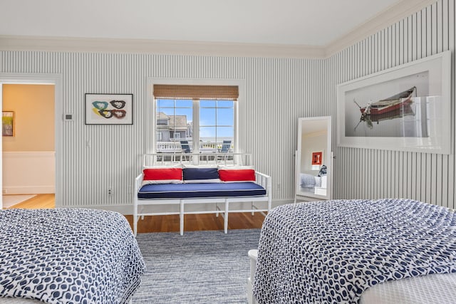 bedroom with ornamental molding, wood finished floors, and baseboards