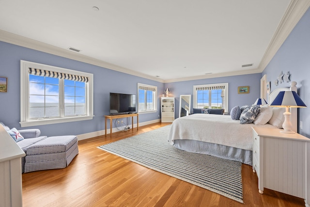 bedroom with multiple windows, ornamental molding, wood finished floors, and baseboards