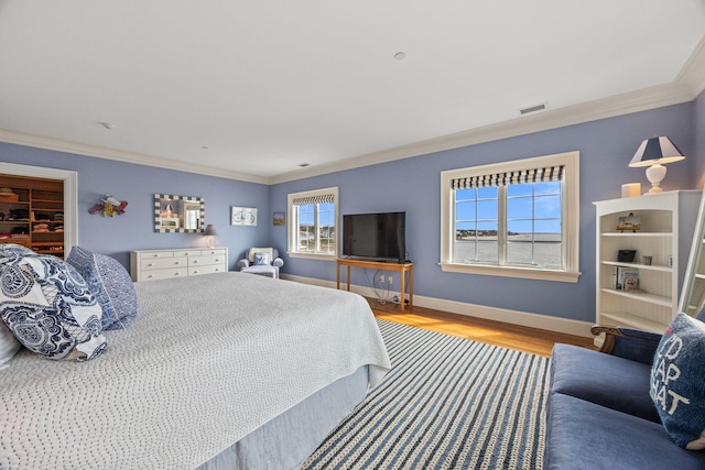 bedroom featuring crown molding, wood finished floors, and baseboards