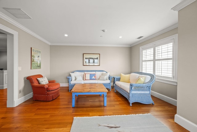 living room with wood finished floors, ornamental molding, baseboards, and recessed lighting