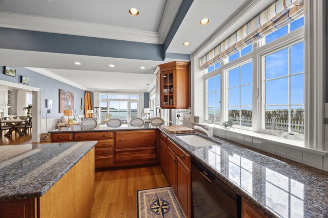 kitchen featuring a sink, dishwasher, crown molding, brown cabinetry, and wood finished floors