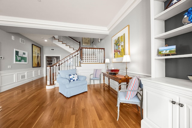 sitting room with stairs, ornamental molding, wood finished floors, and recessed lighting