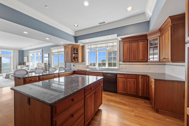 kitchen with black dishwasher, ornamental molding, a sink, brown cabinets, and a peninsula