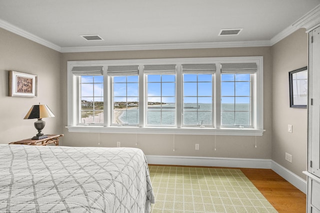 bedroom with light wood-style flooring, ornamental molding, and baseboards