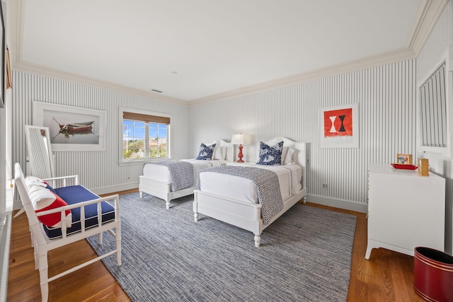 bedroom featuring ornamental molding, wood finished floors, and baseboards