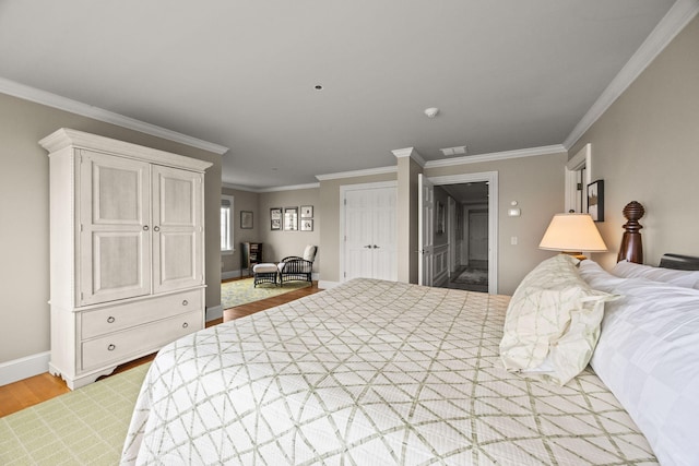 bedroom with light wood finished floors, crown molding, and baseboards