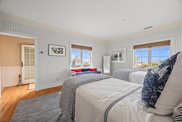 bedroom with ornamental molding, wood finished floors, and baseboards