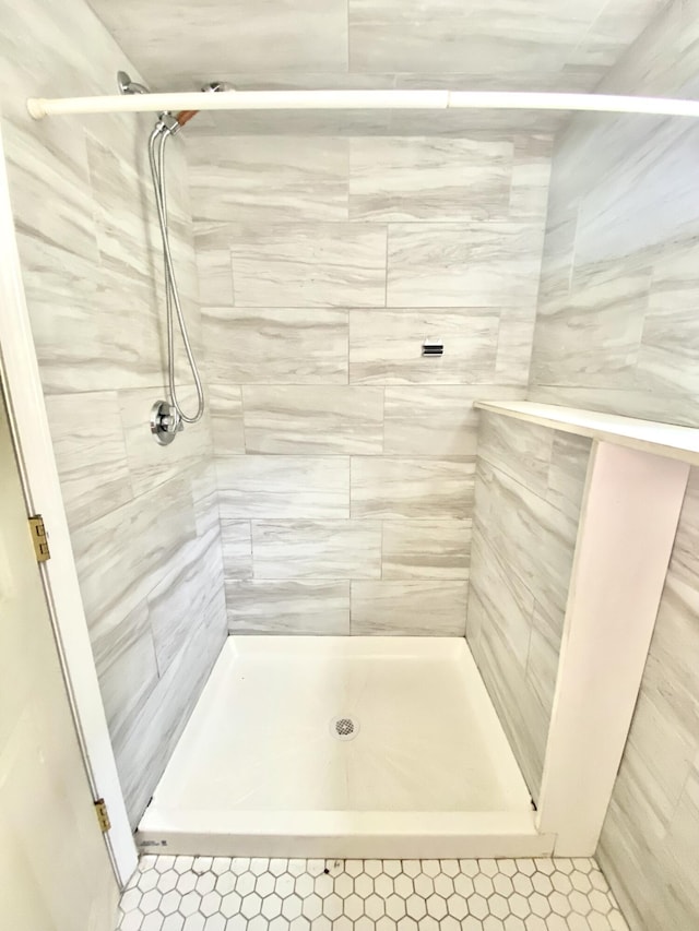 bathroom featuring a tile shower and tile patterned flooring