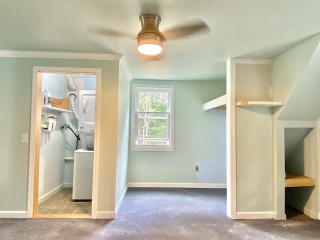 interior space with ceiling fan, light colored carpet, and stacked washer / dryer