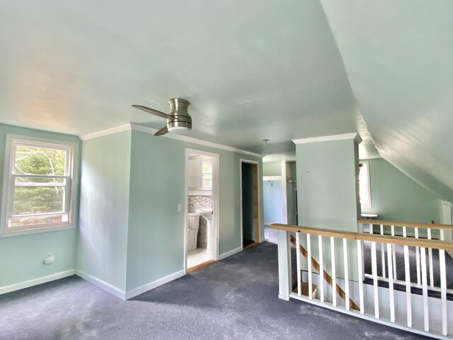 interior space with ceiling fan, vaulted ceiling, ornamental molding, and dark colored carpet