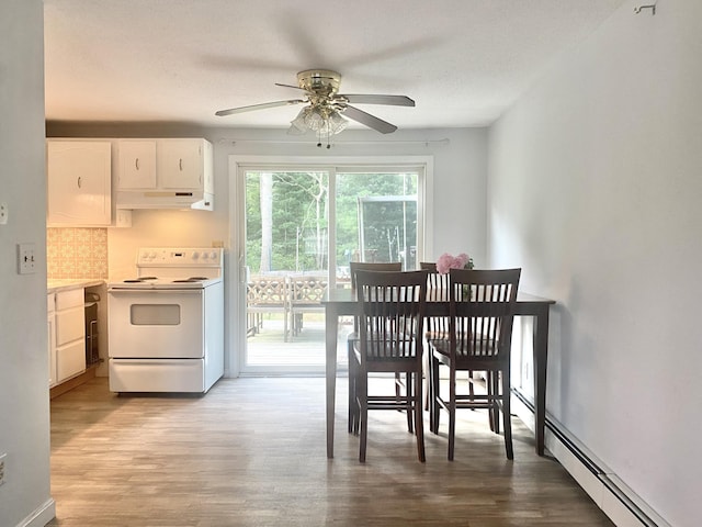 dining room featuring ceiling fan, light wood-type flooring, and a baseboard heating unit