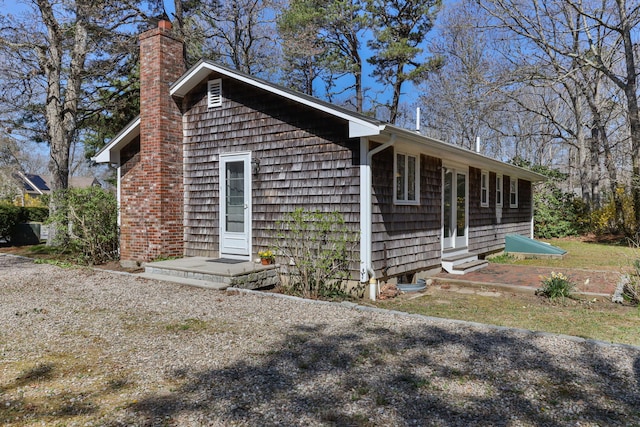 view of property exterior featuring entry steps and a chimney