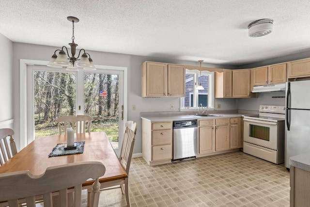 kitchen with a sink, a notable chandelier, light brown cabinets, under cabinet range hood, and white appliances