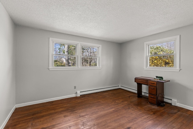 spare room with baseboards, a baseboard heating unit, hardwood / wood-style flooring, and a textured ceiling