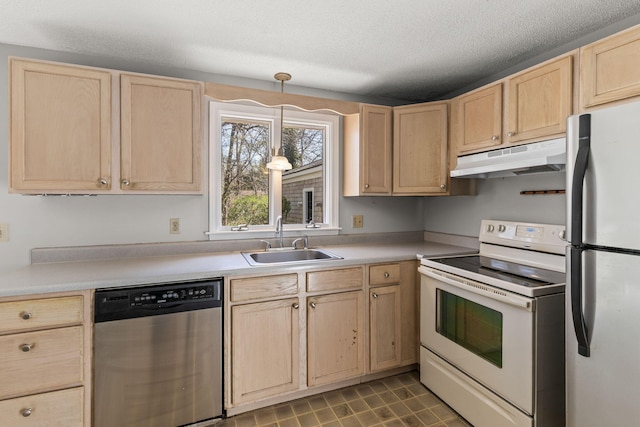 kitchen with a sink, light brown cabinets, and stainless steel appliances
