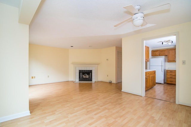 17 Harbor Hill Dr, Bourne, MA 02532 - unfurnished living room with light wood-type flooring, a ceiling fan, and a fireplace