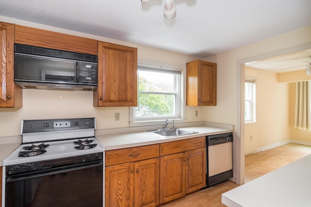17 Harbor Hill Dr, Bourne, MA 02532 - kitchen with range with gas stovetop, black microwave, white dishwasher, light countertops, and brown cabinetry