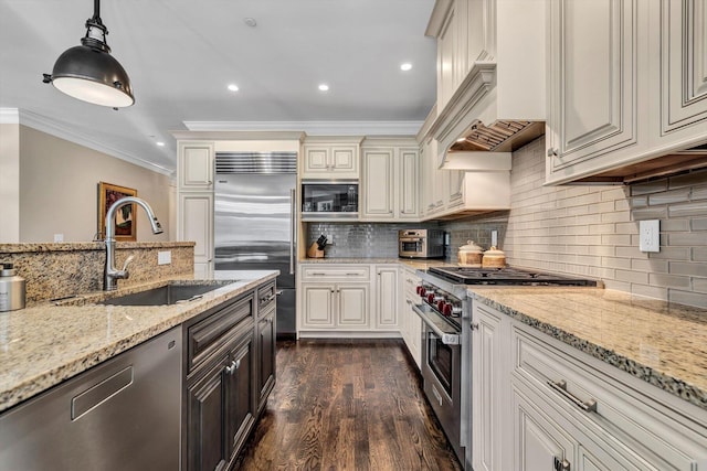 66 Simons Rd Unit A, Mashpee, MA 02649 - kitchen featuring built in appliances, crown molding, light stone counters, dark wood finished floors, and decorative backsplash