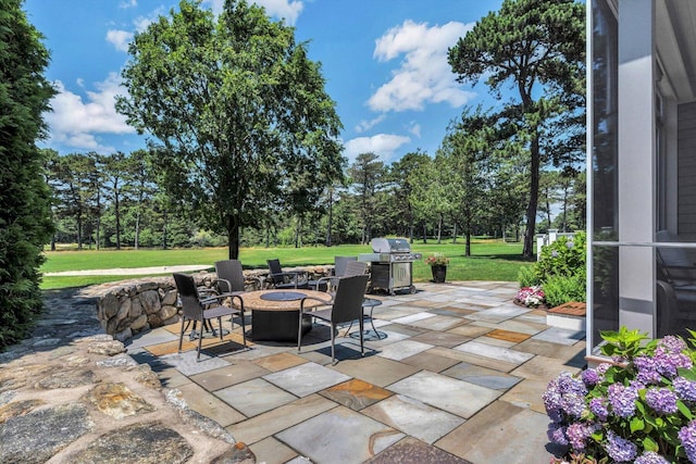 66 Simons Rd Unit A, Mashpee, MA 02649 - view of patio with area for grilling, a fire pit, and view of wooded area