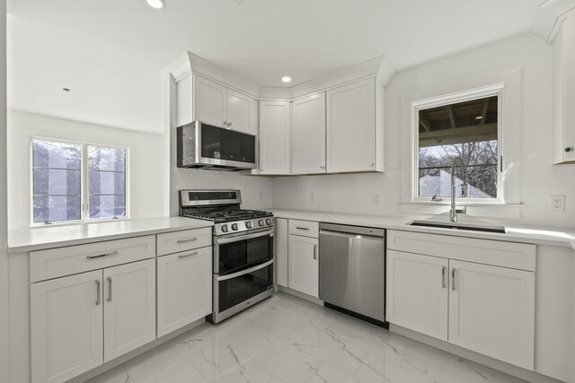 kitchen featuring white cabinets, appliances with stainless steel finishes, and sink