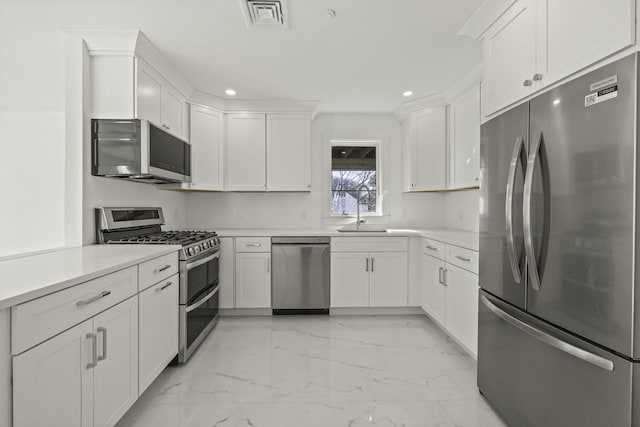 kitchen featuring white cabinets, stainless steel appliances, and sink