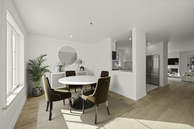 dining room featuring sink and light hardwood / wood-style flooring