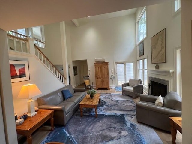 living room featuring hardwood / wood-style flooring, a high ceiling, and a healthy amount of sunlight