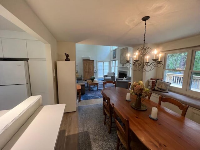 dining area with a wealth of natural light, dark hardwood / wood-style floors, and a notable chandelier