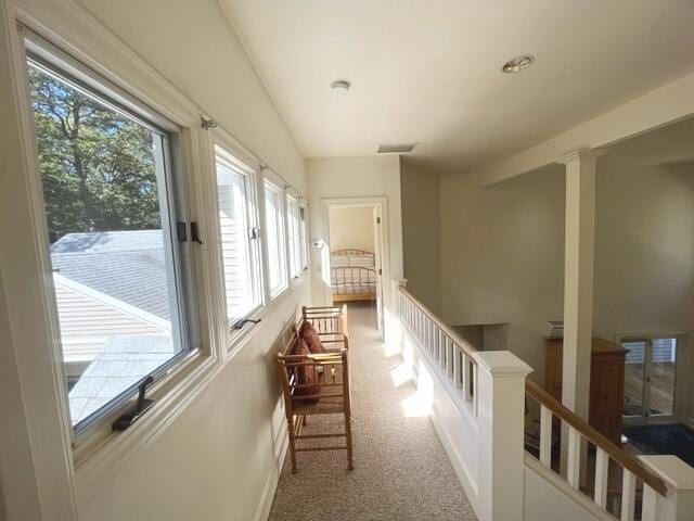 hall featuring light carpet and lofted ceiling