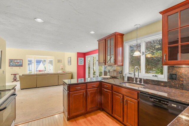 kitchen with pendant lighting, sink, backsplash, light colored carpet, and black dishwasher