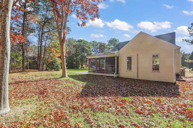 view of property exterior with a sunroom