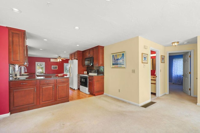 kitchen with white appliances, light carpet, sink, kitchen peninsula, and ceiling fan