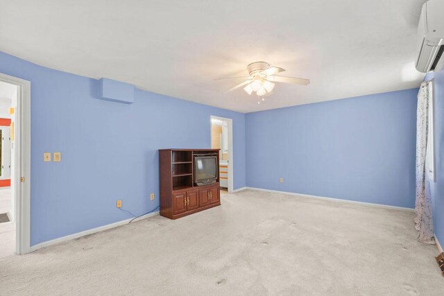 unfurnished bedroom with ceiling fan, light colored carpet, and a wall unit AC