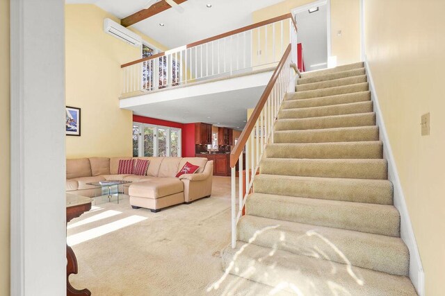 stairway with carpet, a wall unit AC, and a towering ceiling