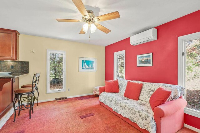 living room featuring ceiling fan, carpet flooring, a wall mounted AC, and a wealth of natural light