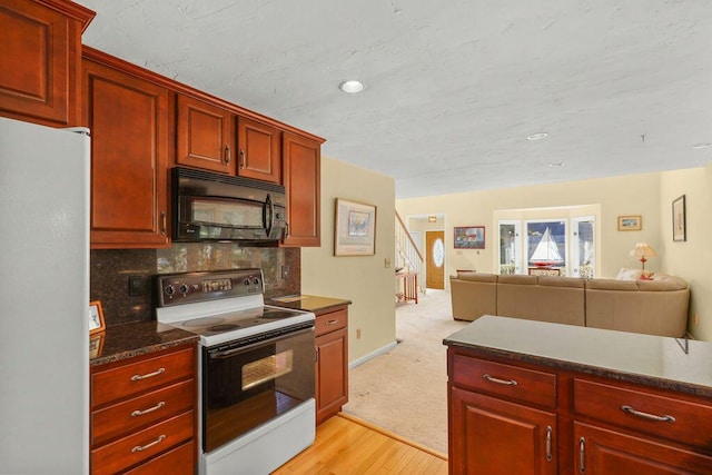 kitchen with white fridge, tasteful backsplash, light hardwood / wood-style floors, and electric stove