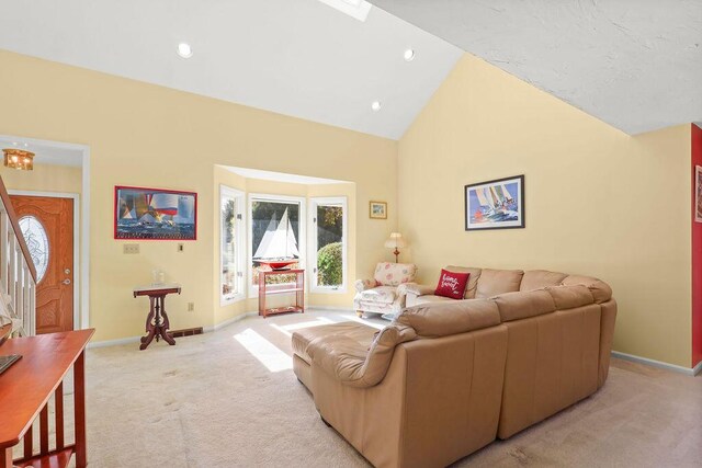 carpeted living room with high vaulted ceiling