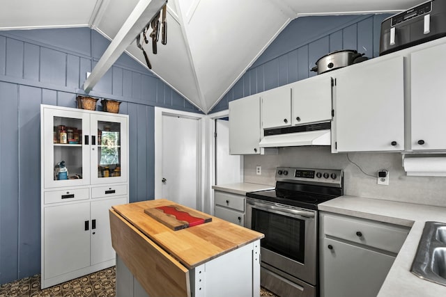 kitchen featuring electric stove, white cabinetry, a center island, and vaulted ceiling