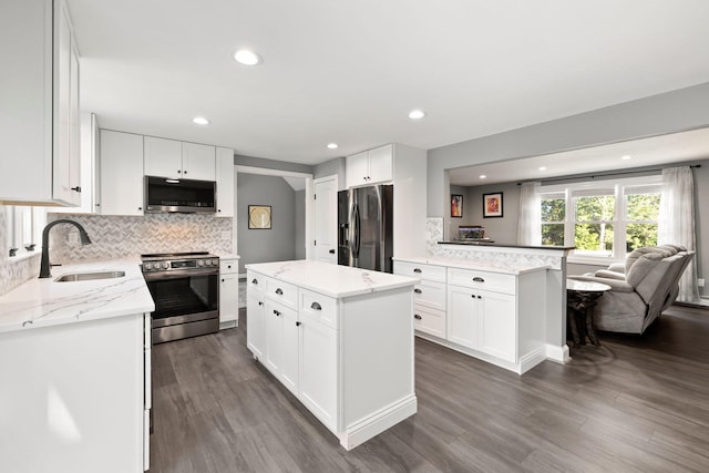 kitchen featuring sink, white cabinets, dark wood-type flooring, a kitchen island, and stainless steel appliances